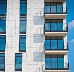 Immeuble neuf blanc avec des balcons et des grandes fenêtres