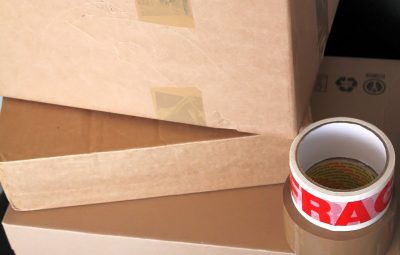 Cartons de déménagement empilés avec des rouleaux de scotch posés au-dessus