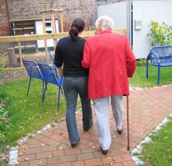 résident de maison de retraite en promenade avec un soignant