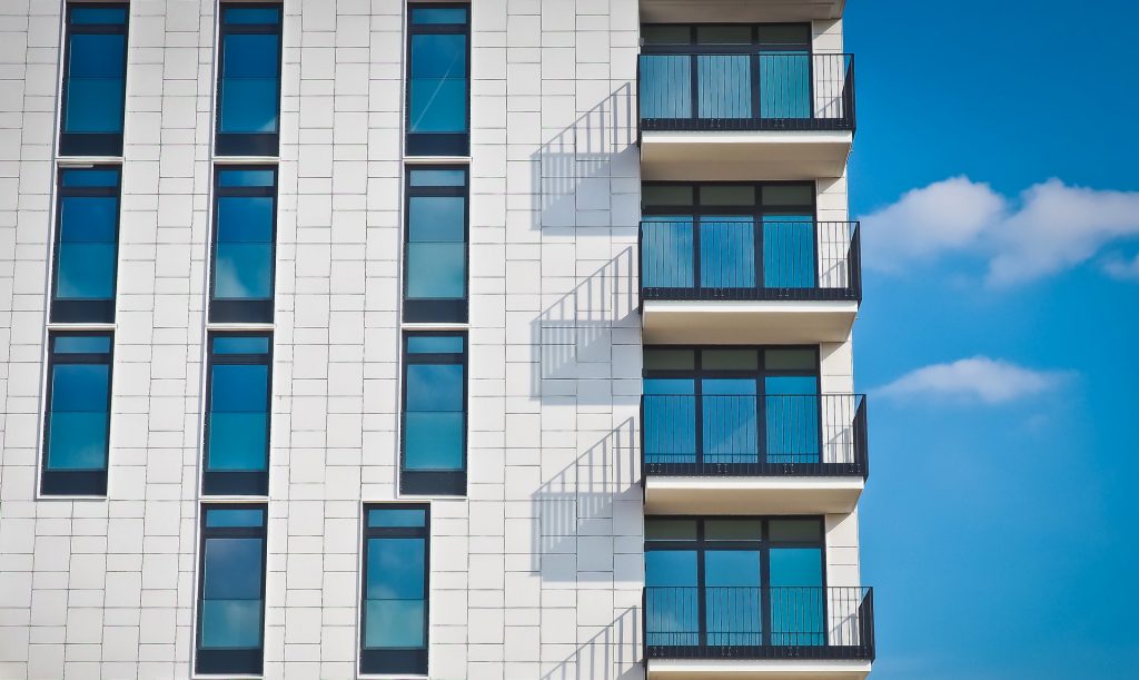 Immeuble neuf blanc avec des balcons et des grandes fenêtres