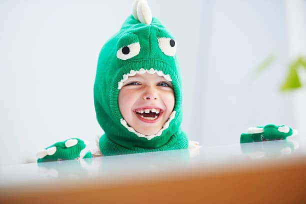 Gros plan sur le visage d'un enfant déguisé en dinosaure
