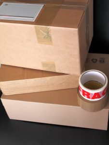 Cartons de déménagement empilés avec des rouleaux de scotch posés au-dessus