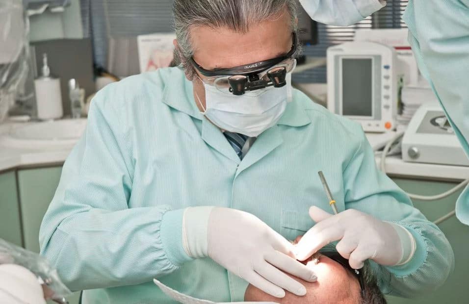 Dentiste qui effectue des soins dentaires sur une patiente